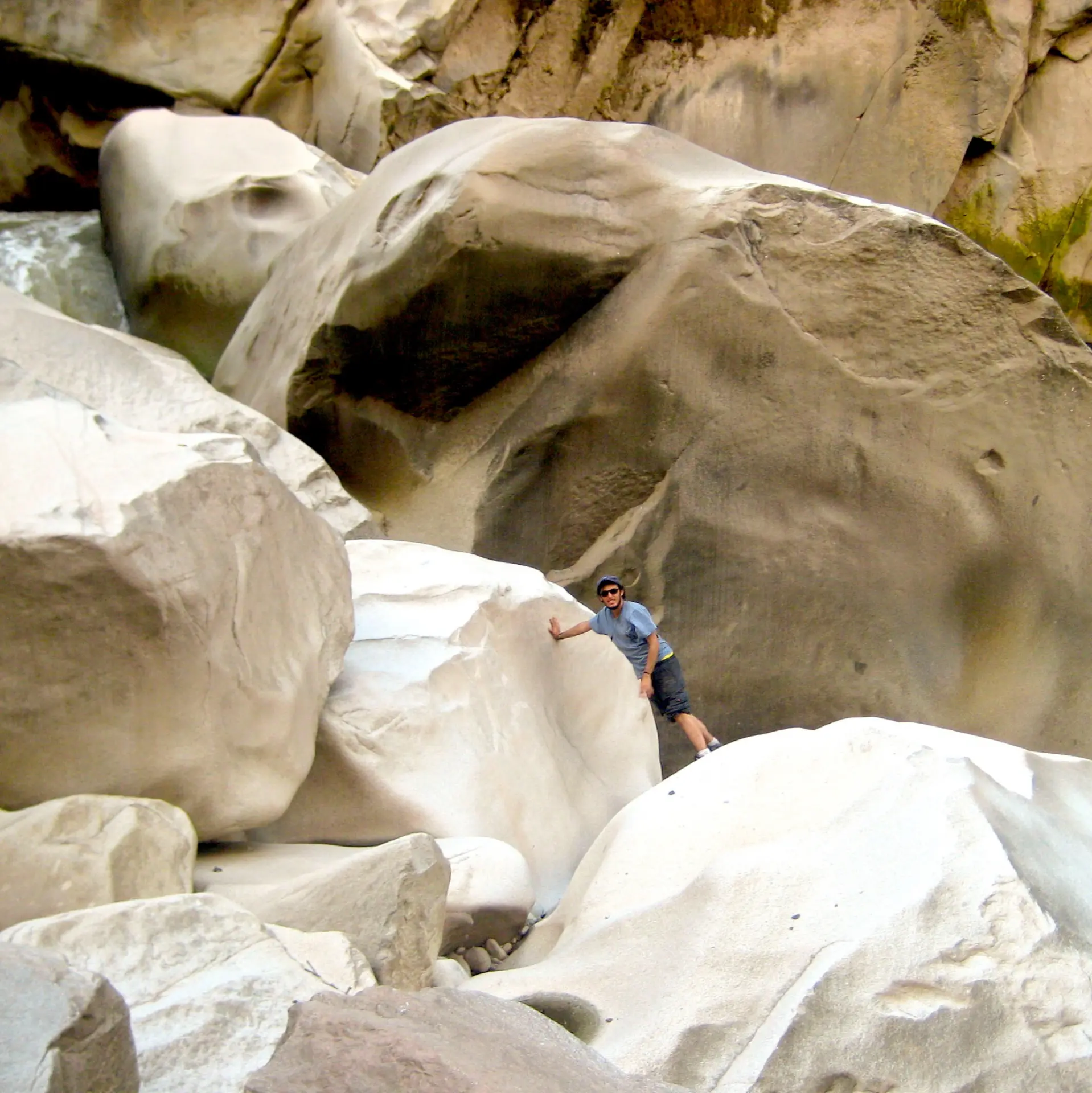 Andy explorando entre grandes rocas talladas por el río