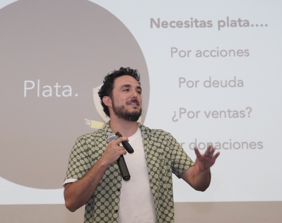 Andy dando una conferencia con micrófono