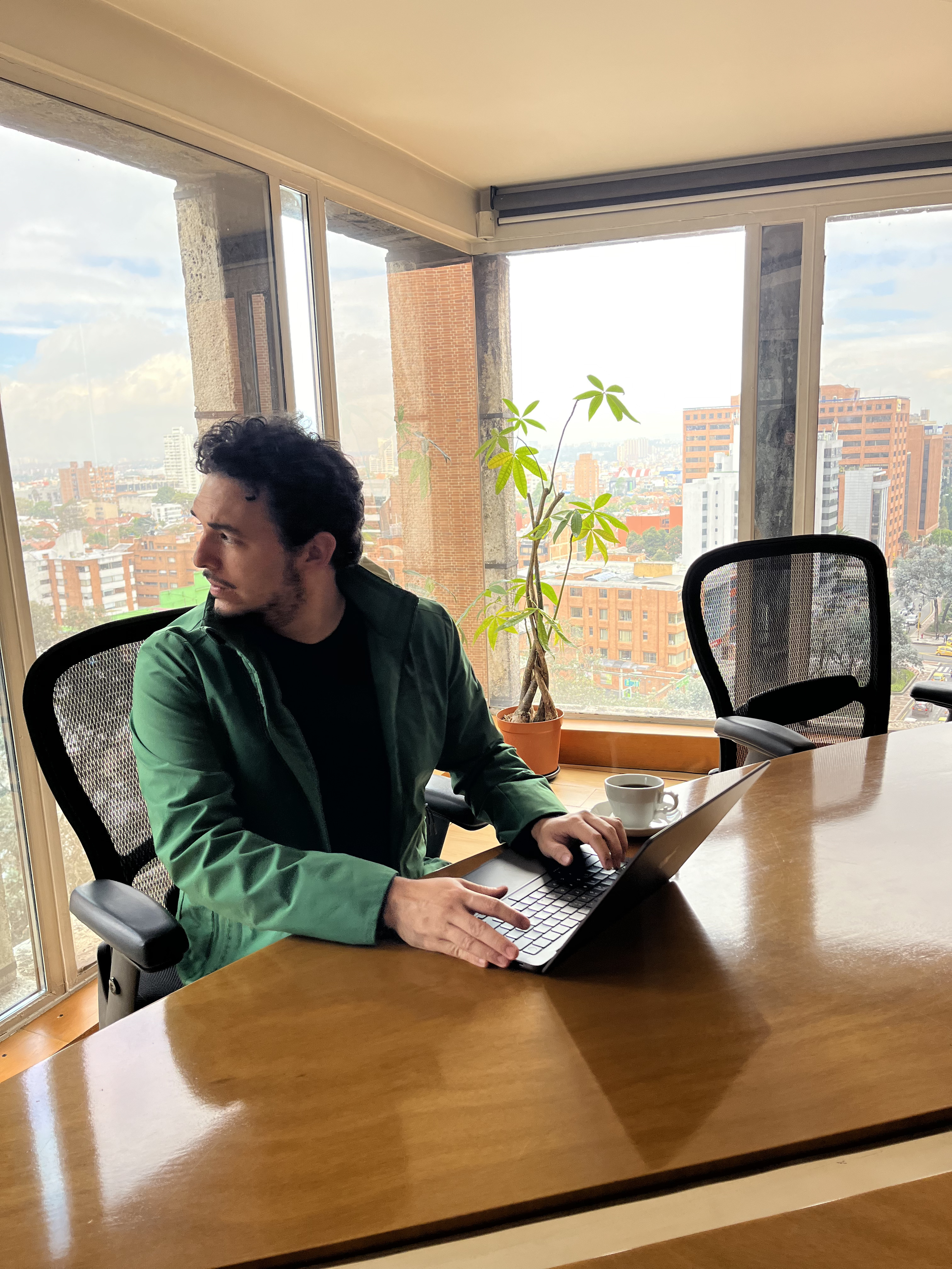 Andy en oficina con Bogotá al fondo
